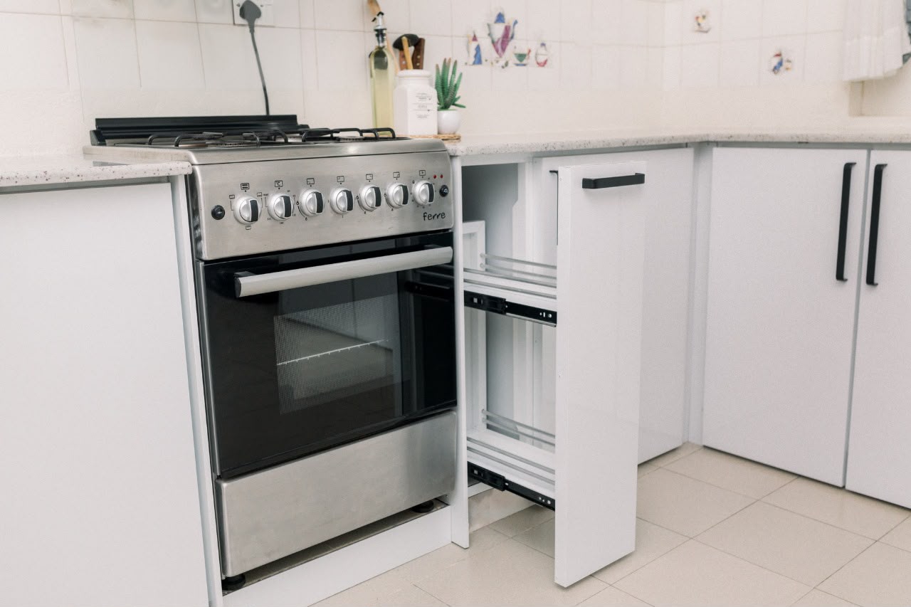 White kitchen with pull-out drawer next to oven